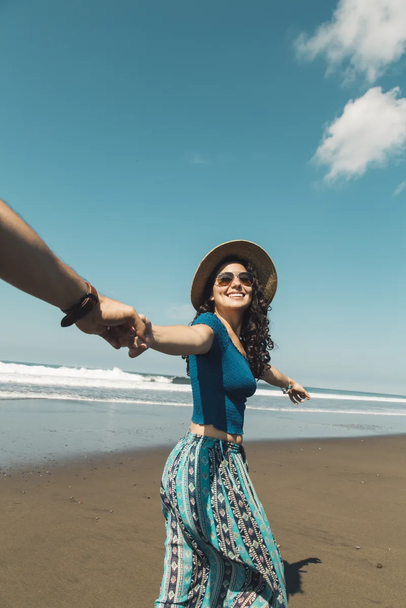 Couple holding hands on a sandy beach in Baja — follow-me lifestyle moment