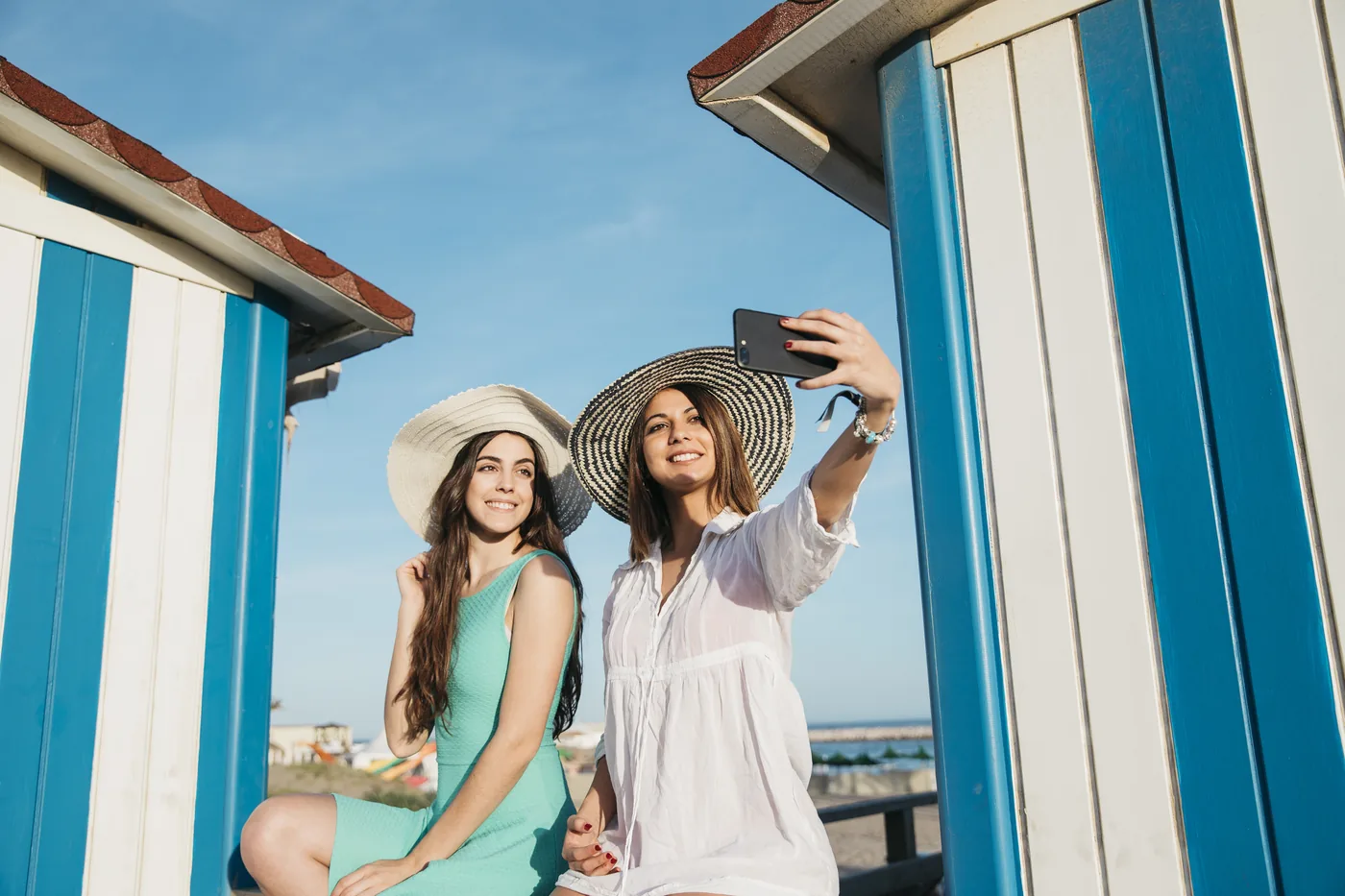 Friends taking a selfie with a bright blue striped wall in Cabo